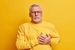 Mężczyzna z bólem w klatce piersiowej, symbolizujący zwiększone ryzyko wystąpienia chorób serca.